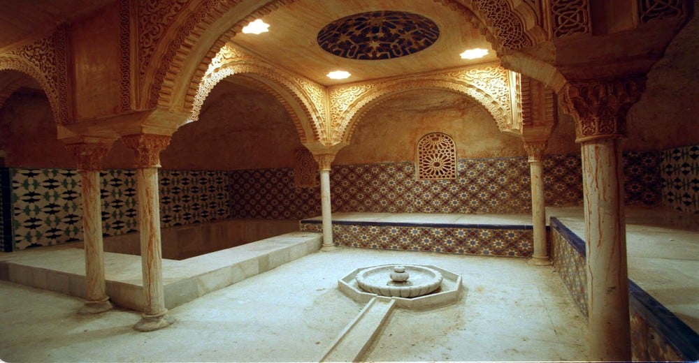 Bains arabes traditionnels en Andalousie avec arches mauresques, zellige et fontaine centrale