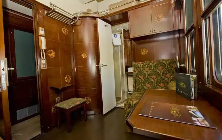Int&eacute;rieur d'une cabine Gran Clase du train Al Andalus avec salle de bain priv&eacute;e et boiseries