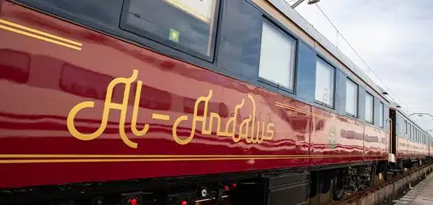 Voiture du train Al Andalus en gare avec logo dor&eacute; sur livr&eacute;e bordeaux