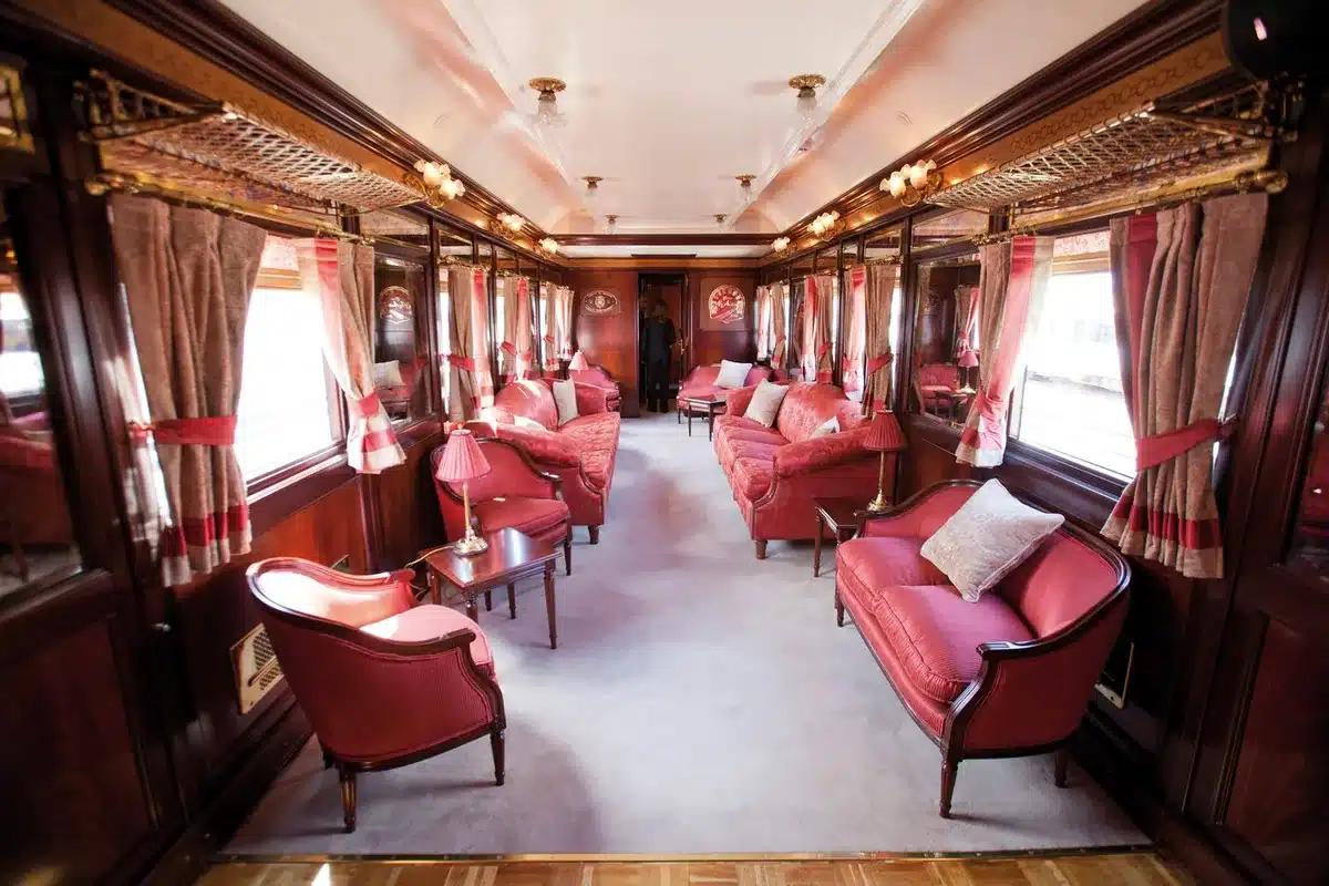 Voiture-salon Belle &Eacute;poque du train Al Andalus avec banquettes en velours rouge et boiseries d'origine